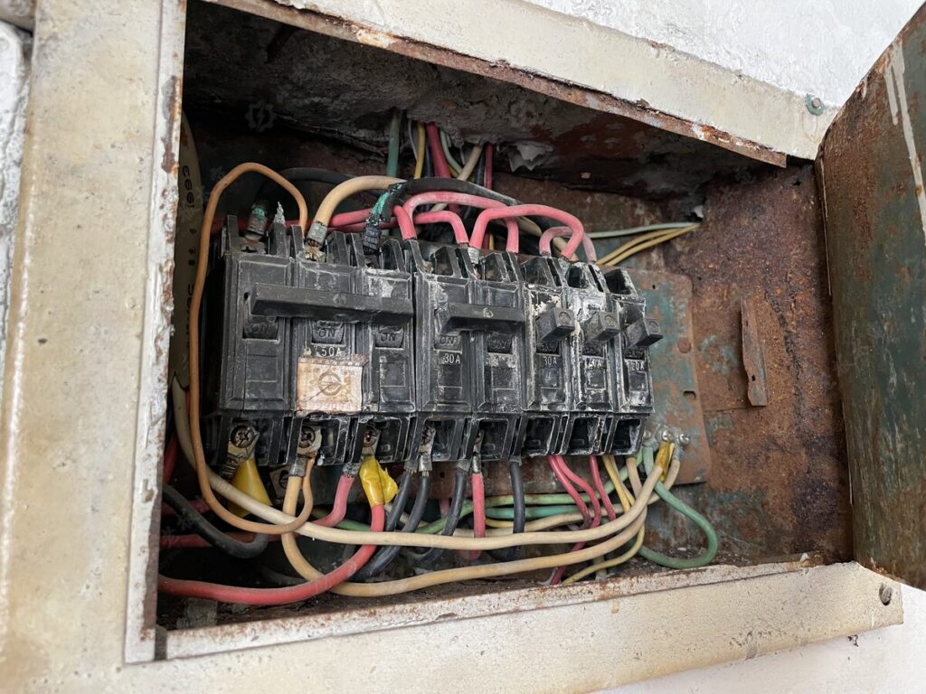 老舊配電箱內部,斷路器與配線老化、外箱生鏽、迴路雜亂